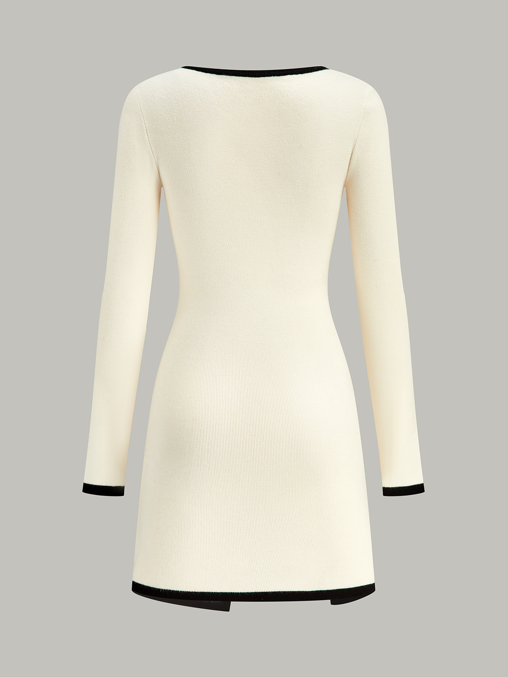 A cream sweater dress with long sleeves and black trim at neckline, cuffs, and hem.