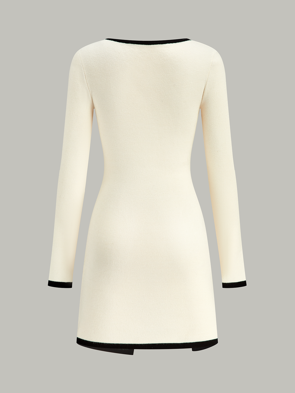 A cream sweater dress with long sleeves and black trim at neckline, cuffs, and hem.