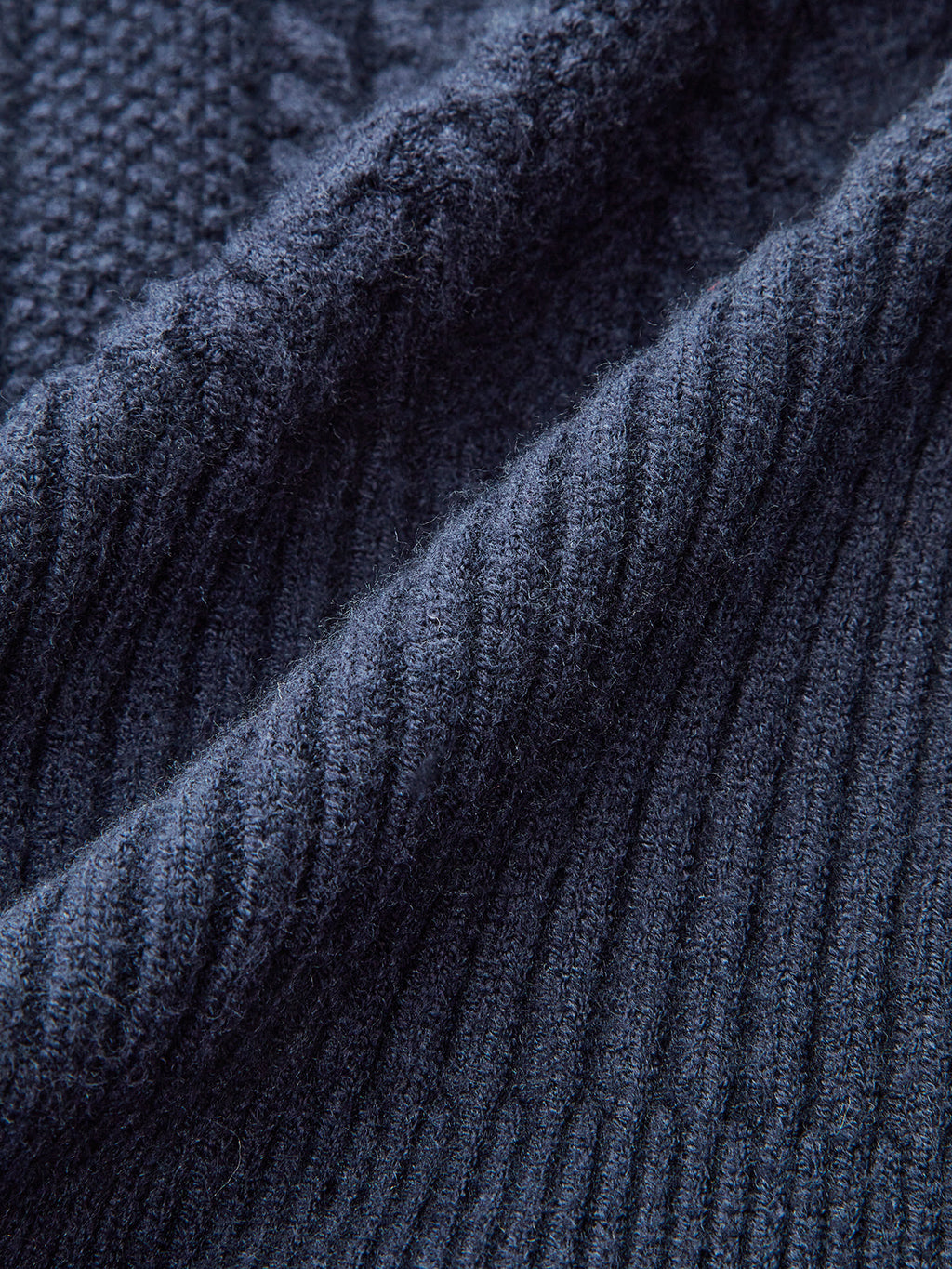 Denim collar peplum cardigan in dark blue stretch knit with ribbed texture and cable details.