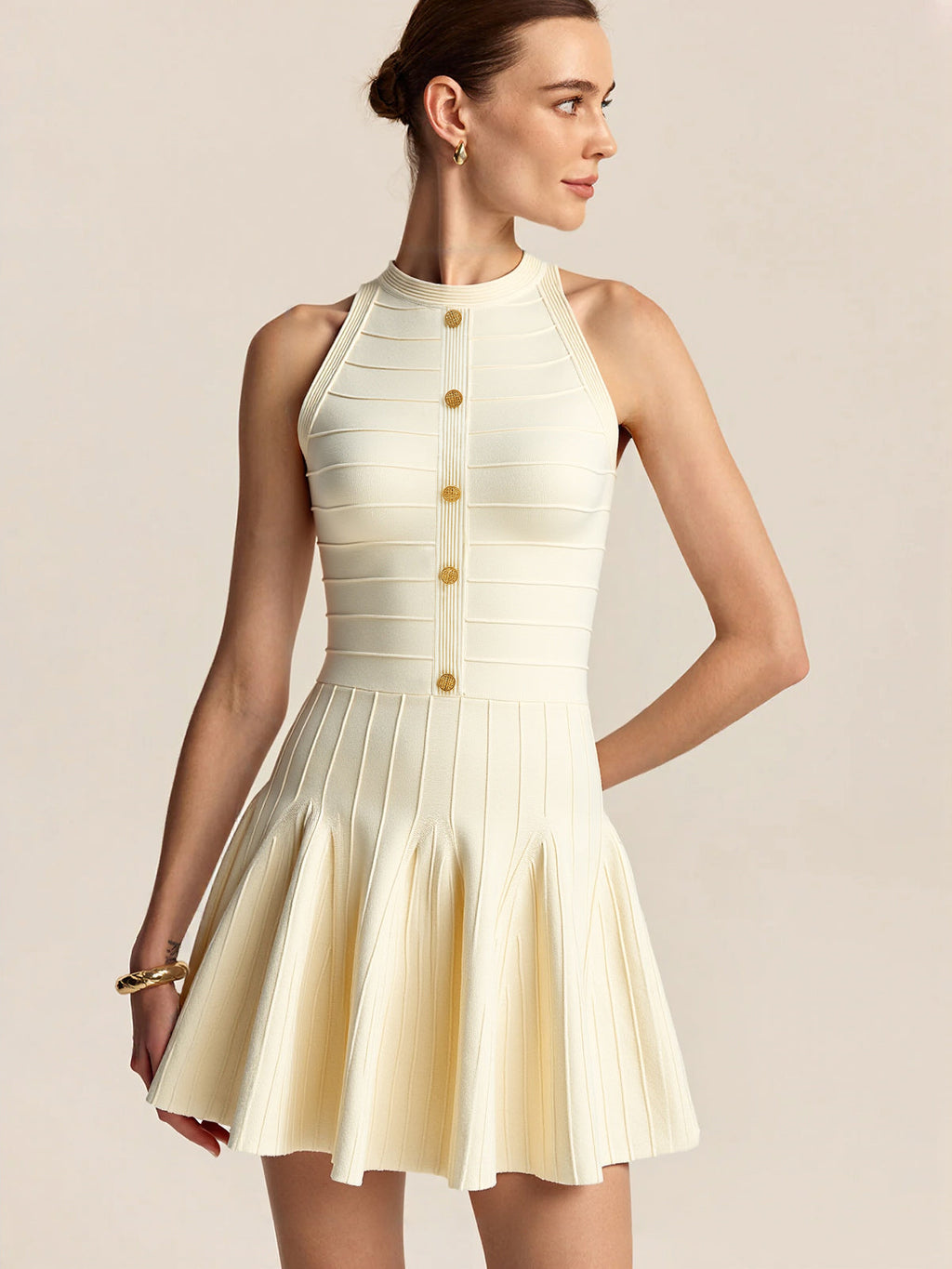 A sleeveless, slim-fit backless halter sweater dress with gold buttons and a flared skirt.