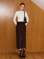 Asymmetric wool blend top with metal detail and cut-out design, high-waisted brown midi skirt.