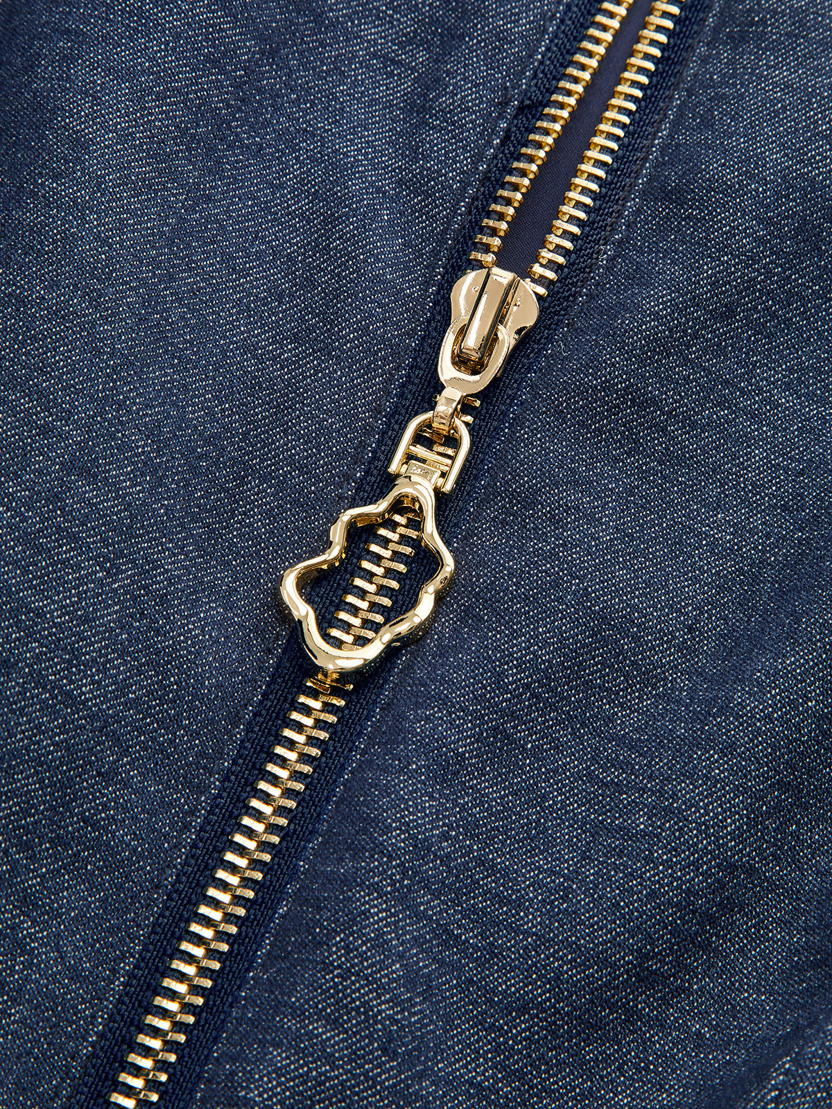 Gold zipper and pull detail on dark blue LA FINE FLEUR denim zip-front dress.