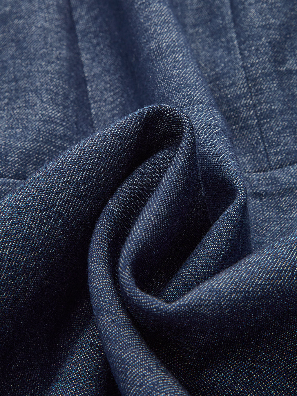 Dark blue denim dress with visible weave and soft folds, featuring a zip-front design.