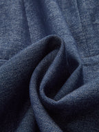 Dark blue denim dress with visible weave and soft folds, featuring a zip-front design.