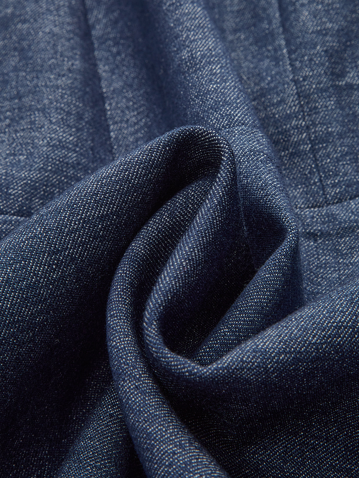 Dark blue denim dress with visible weave and soft folds, featuring a zip-front design.