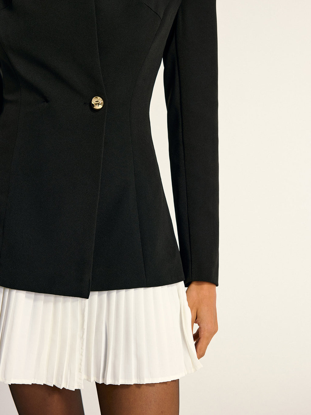 The LA FINE FLEUR blazer dress has gold buttons and a white pleated skirt panel.