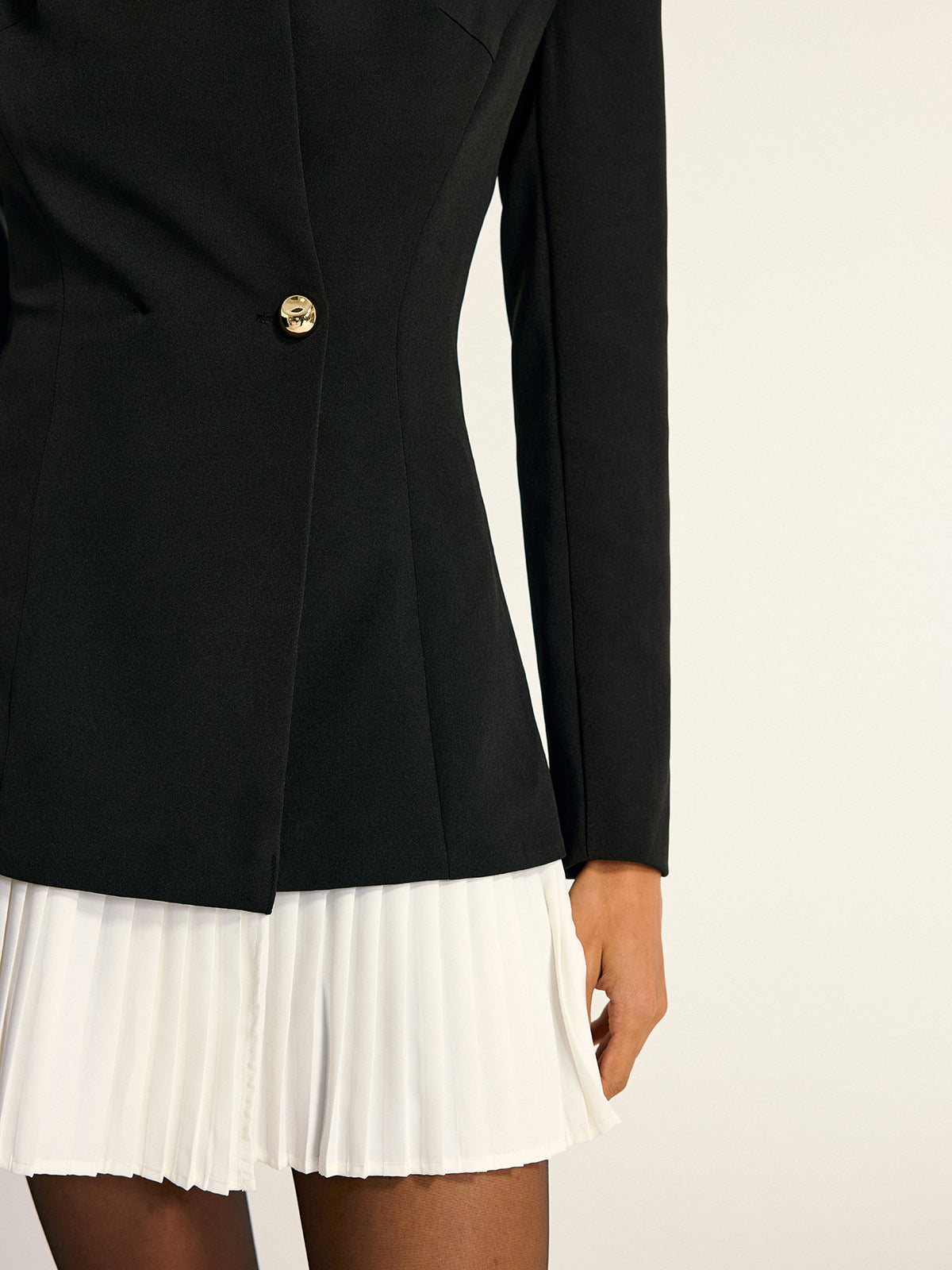 The LA FINE FLEUR blazer dress has gold buttons and a white pleated skirt panel.
