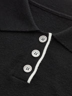 Slim-fit black knit polo crop with collar, white contrast trim, and three white buttons.