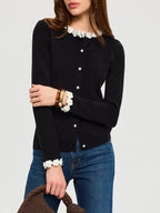 The LA FINE FLEUR 3D Floral Embroidered Cardigan with Elegant Pearl Buttons and blue jeans.