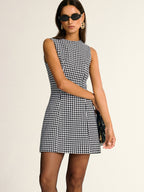 Chic houndstooth pattern sleeveless A-line mini dress with a fitted bodice and flared skirt.