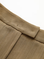 Striped pleated trousers with wide-leg cut, featuring detailed waistband stitching and textured fabric.