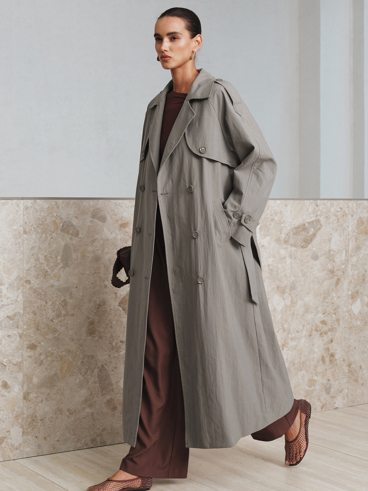 LA FINE FLEUR belted cotton oversize trench coat layered over a brown outfit.