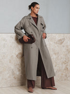 LA FINE FLEUR Belted Cotton Oversize Trench Coat paired with brown wide-leg pants.