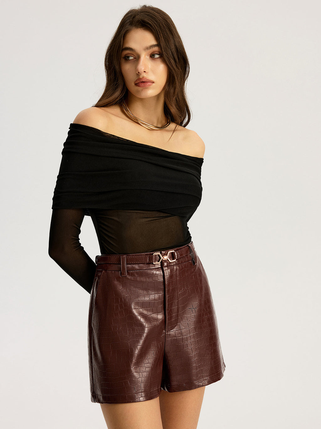 Burgundy belted faux leather shorts paired with a black off-the-shoulder mesh top.