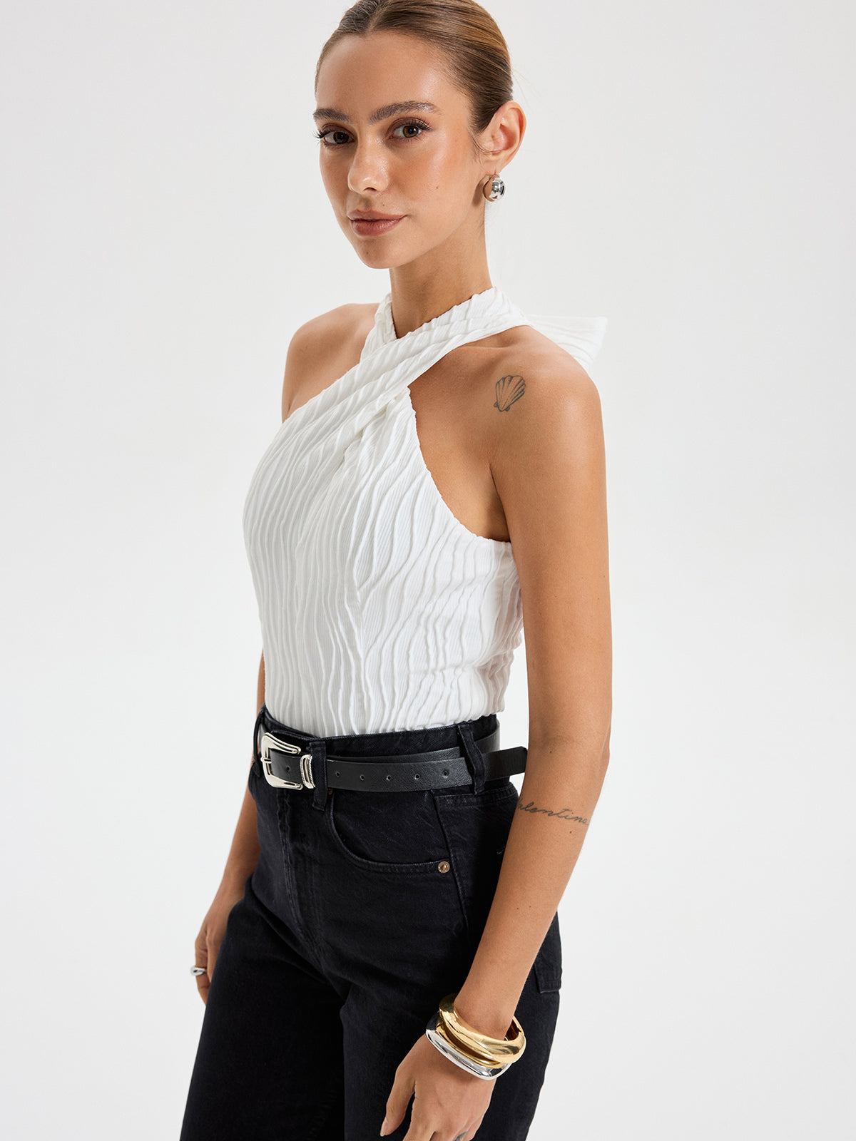 BYPINKYPARIS Crisscross Textured Halter Neck Top paired with high-waisted black jeans and belt.