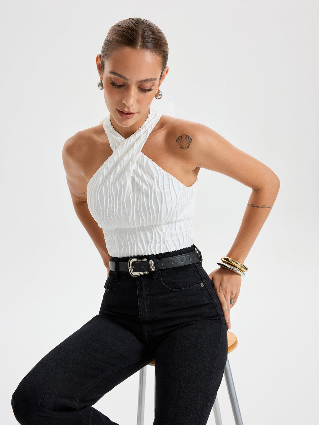 BYPINKYPARIS Crisscross Textured Halter Neck Top paired with high-waisted black jeans.