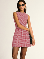 A sleeveless A-line mini dress featuring a chic black-and-white houndstooth pattern.