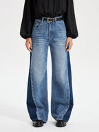 Two-tone wide leg barrel jeans with color-block panels, styled with a relaxed fit.