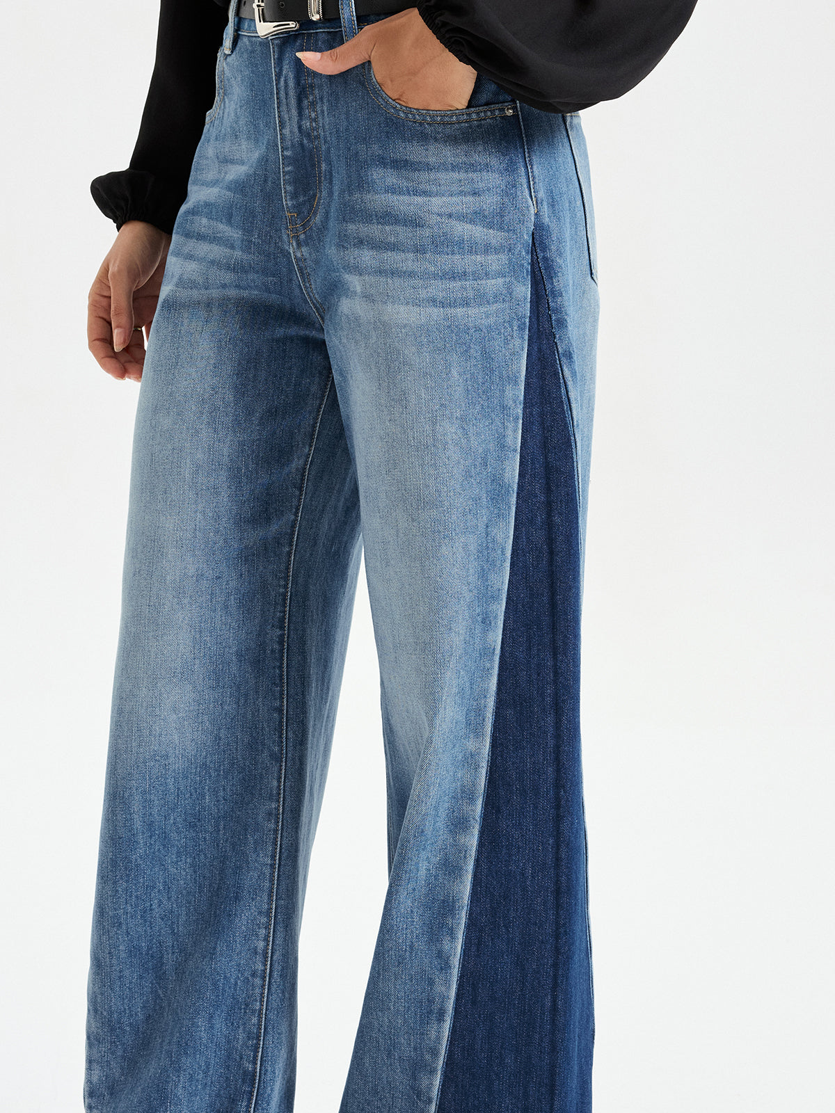 Two-tone barrel jeans with mid-rise, light-wash front and dark denim sides, black top.