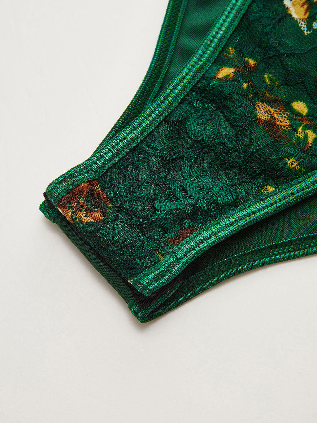 Floral embroidered bustier corset bodysuit with green lace details and elegant structure.