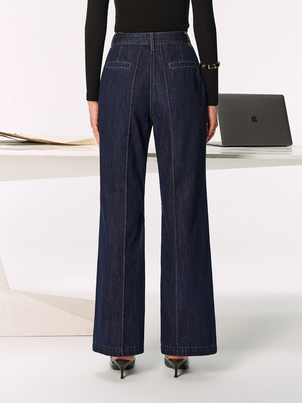 LA FINE FLEUR’s mid-rise jeans with chic side slits, paired with black heels.