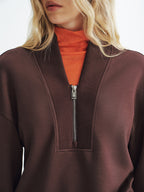 A V-neck half-zip cozy pullover sweatshirt layered over an orange turtleneck sweater.