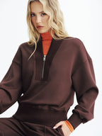 Brown LA FINE FLEUR V-Neck Half-Zip Cozy Pullover layered over an orange turtleneck.