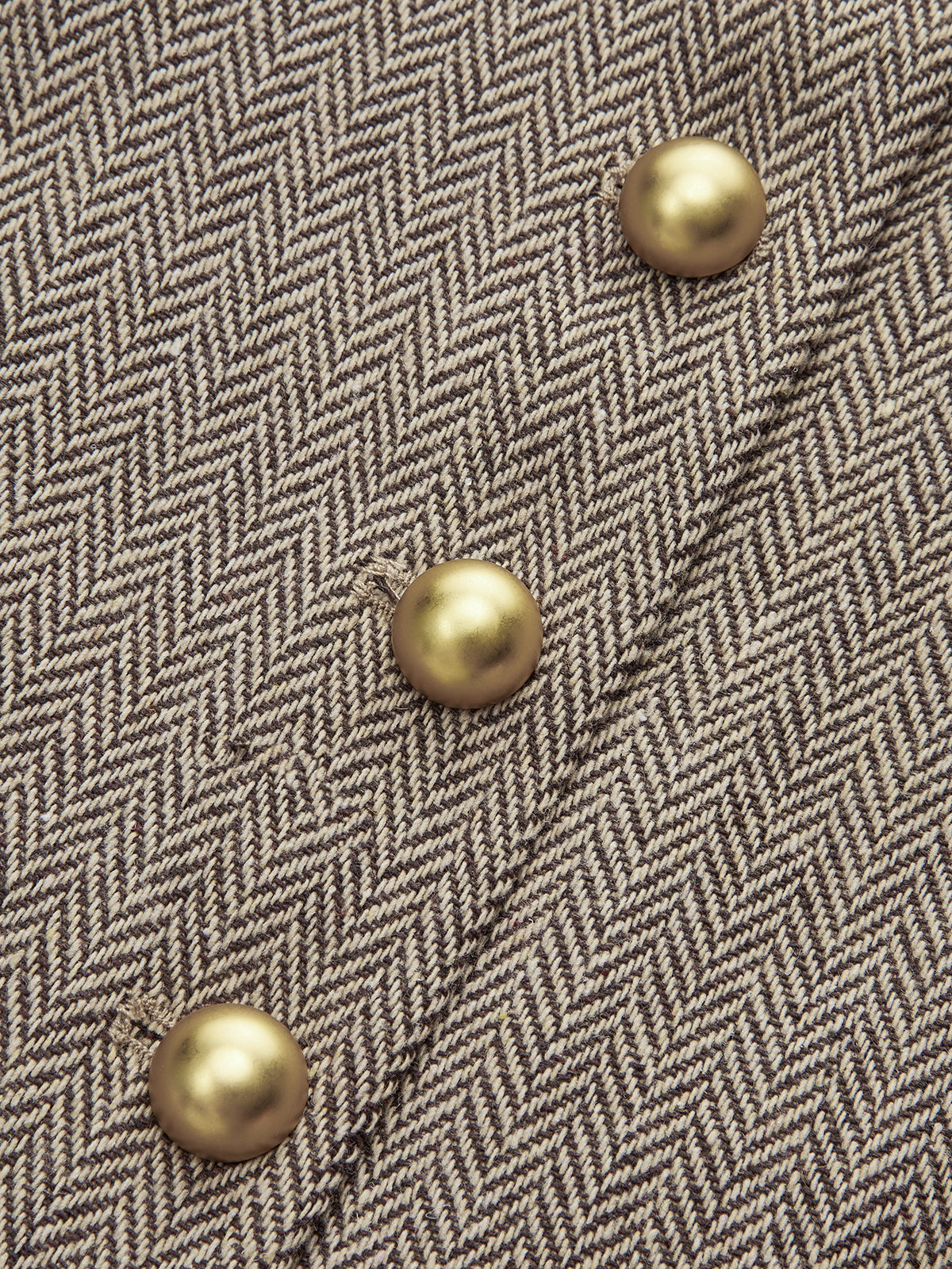 Beige and brown plaid mini dress with pleated skirt and four diagonal gold snap buttons.