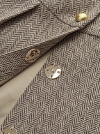 Herringbone plaid mini dress with pleated skirt, gold and silver snap buttons, long sleeves.