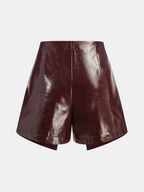 Shimmering rose gold faux leather mini skort with a high waist and angular wrap hem.