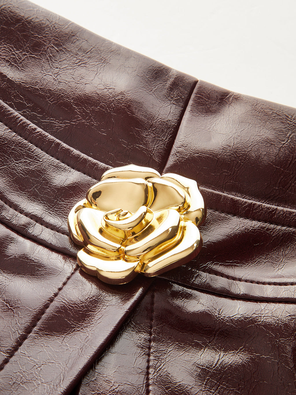 Dark brown leather mini skort with a luxe, shimmering finish and subtle wrinkles.