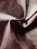 Shimmering rose gold faux leather mini skort with visible creases, folds, and textured shine.
