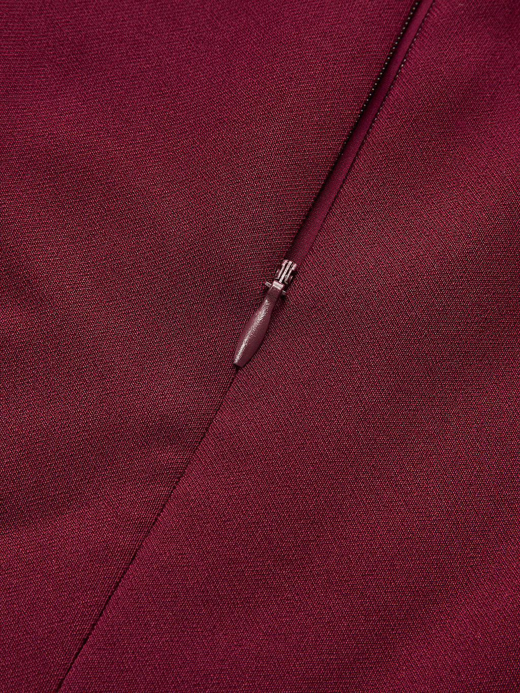 Burgundy sleeveless mini dress with asymmetric ruffle hem, woven texture, tailored seams, concealed zipper.