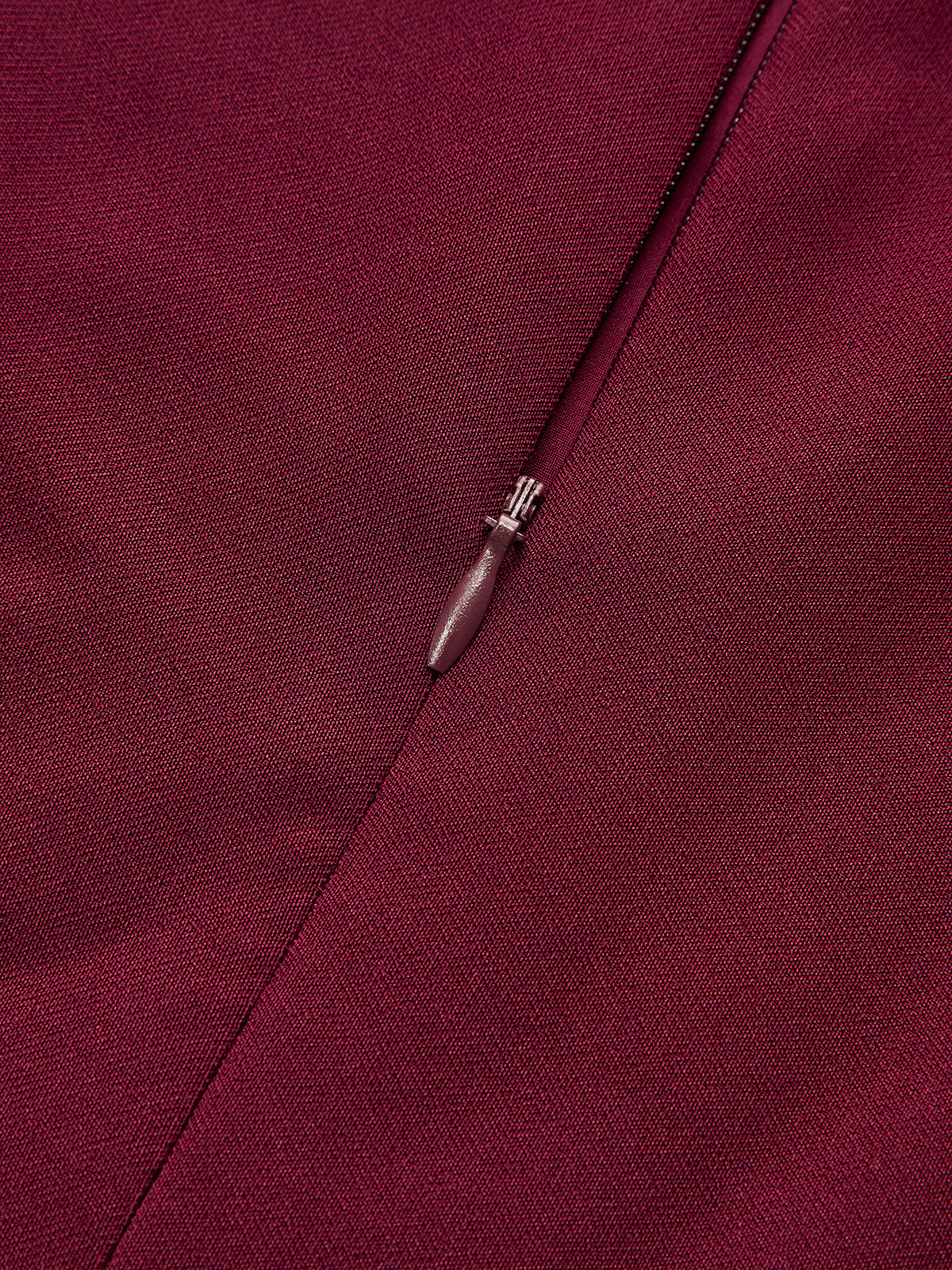 Burgundy sleeveless mini dress with asymmetric ruffle hem, woven texture, tailored seams, concealed zipper.