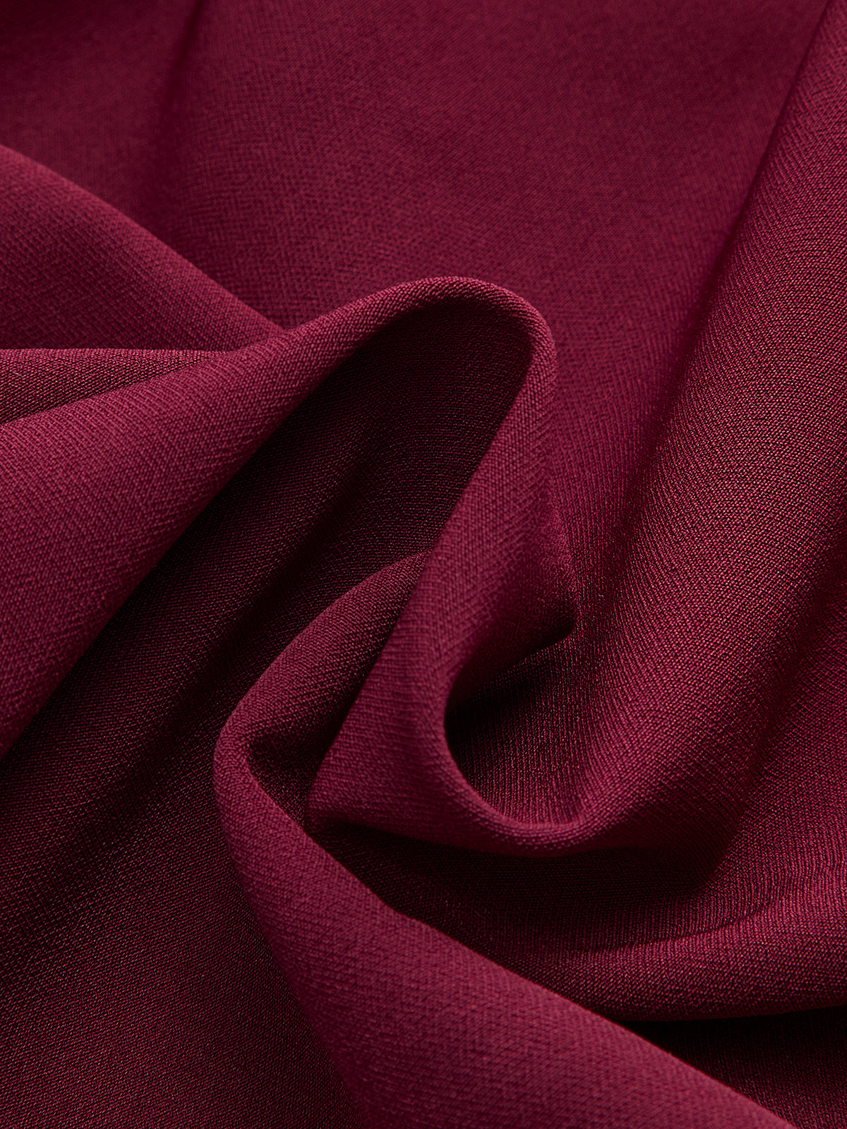 Sleeveless burgundy mini dress with asymmetric ruffle hem, woven fabric, soft folds, subtle texture.