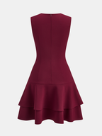 Burgundy sleeveless mini dress with crew neck, fitted bodice, back zip and asymmetric ruffle hem.