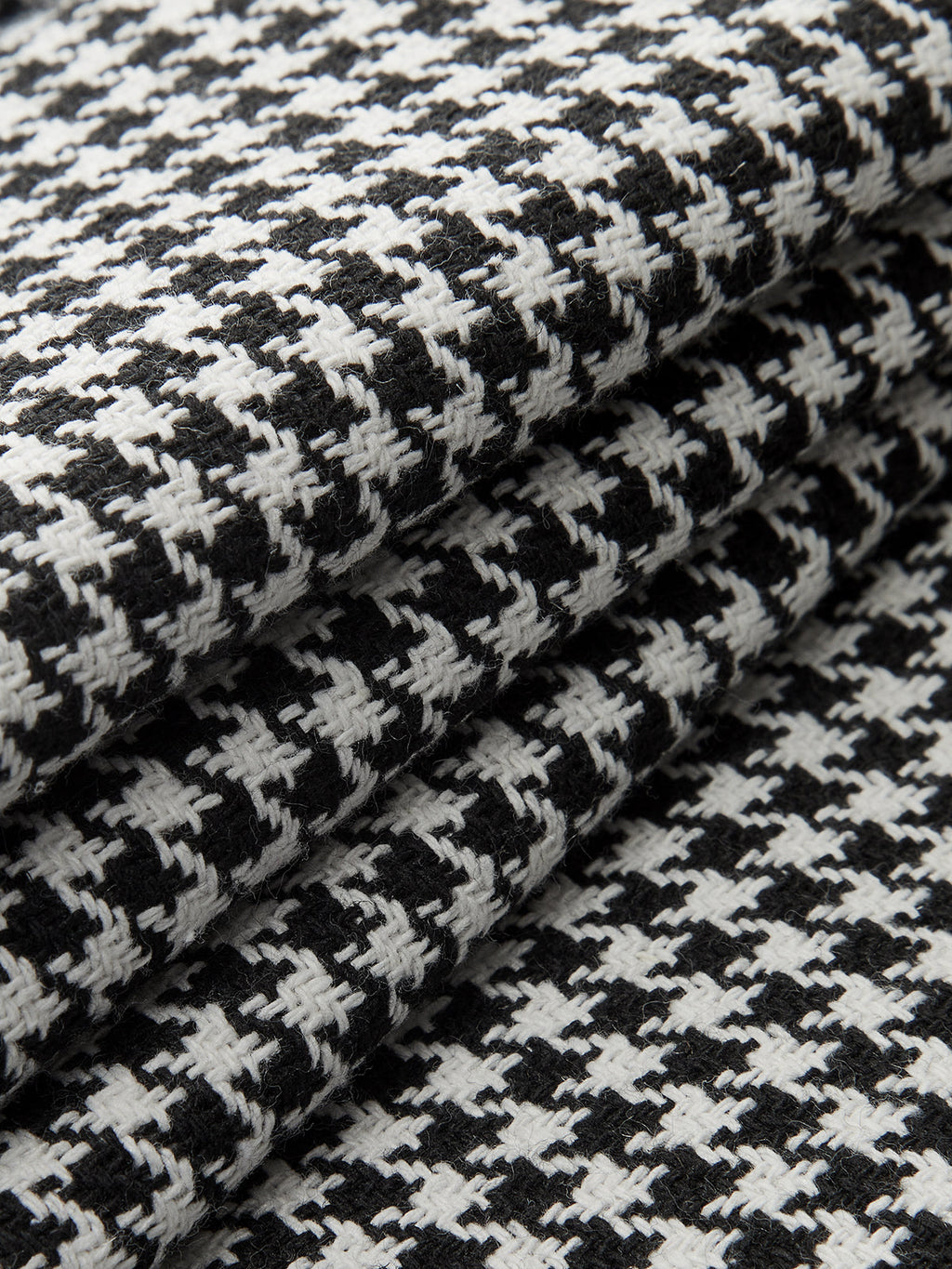 Black and white houndstooth pleated wide leg pants featuring distinctive button details throughout.