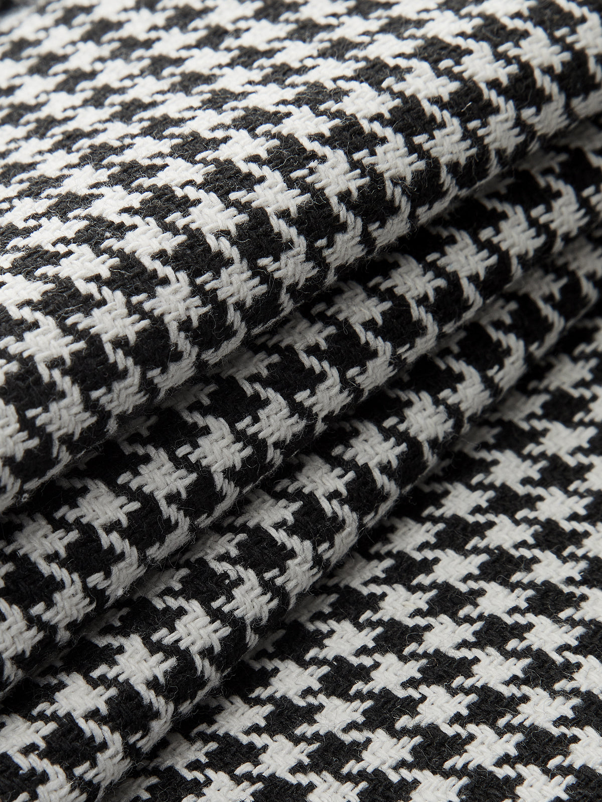 Black and white houndstooth pleated wide leg pants featuring distinctive button details throughout.