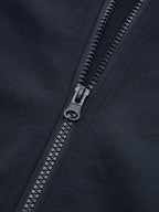 Cropped athletic sweatshirt with black zipper, detailed teeth, and visible precise stitching on dark fabric.
