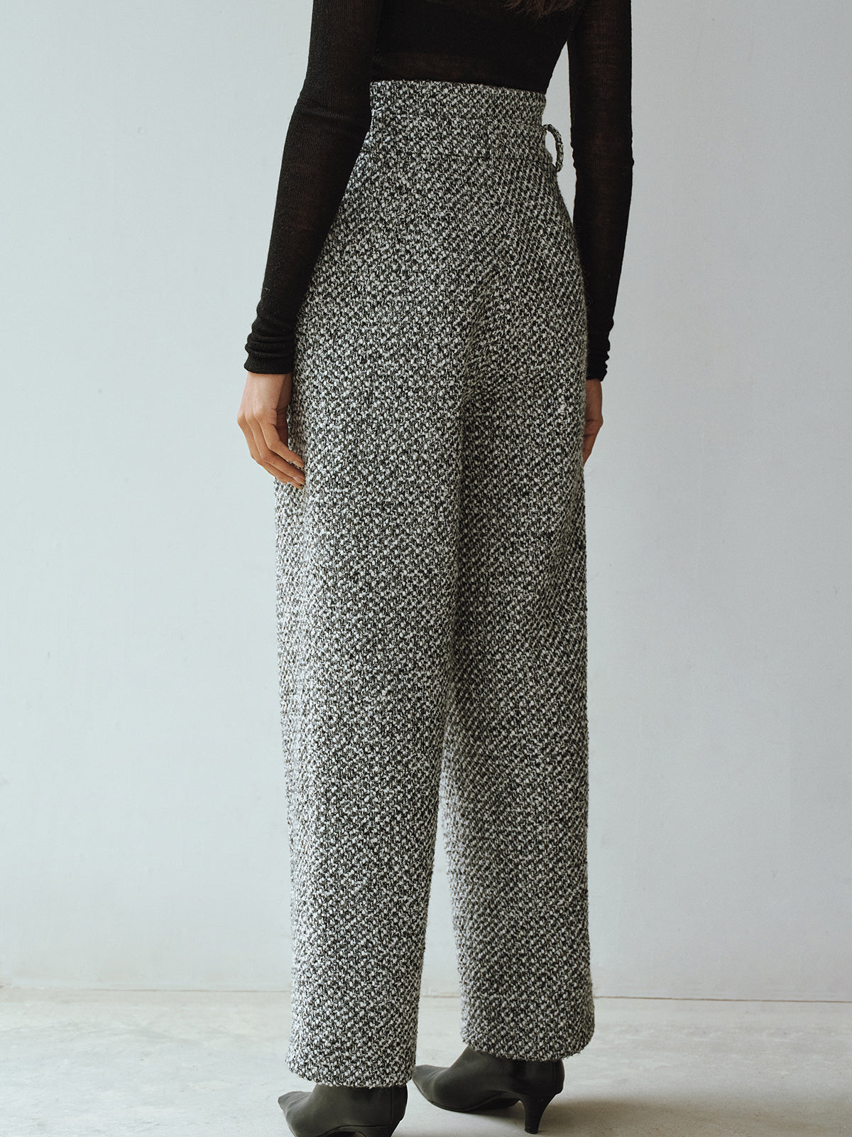 LA FINE FLEUR Double Waistband Wool Blend Tweed Trousers and long-sleeve black top.