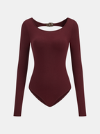Backless long-sleeve bodysuit with scoop neckline, buckled detail, high-cut legs, and clasp closure.