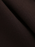 Close-up of a dark brown ribbed knit shirt dress with vertical textured lines and folds.