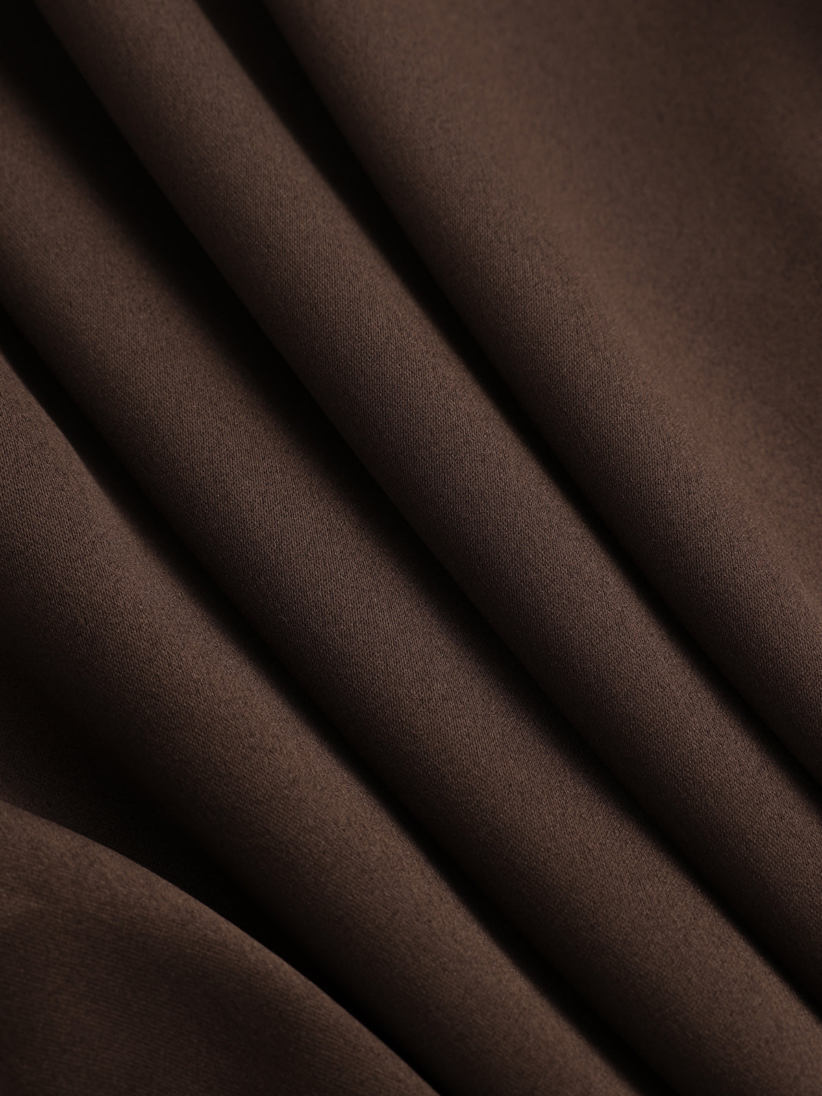 Brown ribbed knit shirt dress with soft diagonal folds, subtle sheen, and belted panel detail.