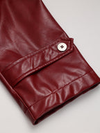 Close-up of a faux leather red-sleeved trench coat with strap and white cuff button.