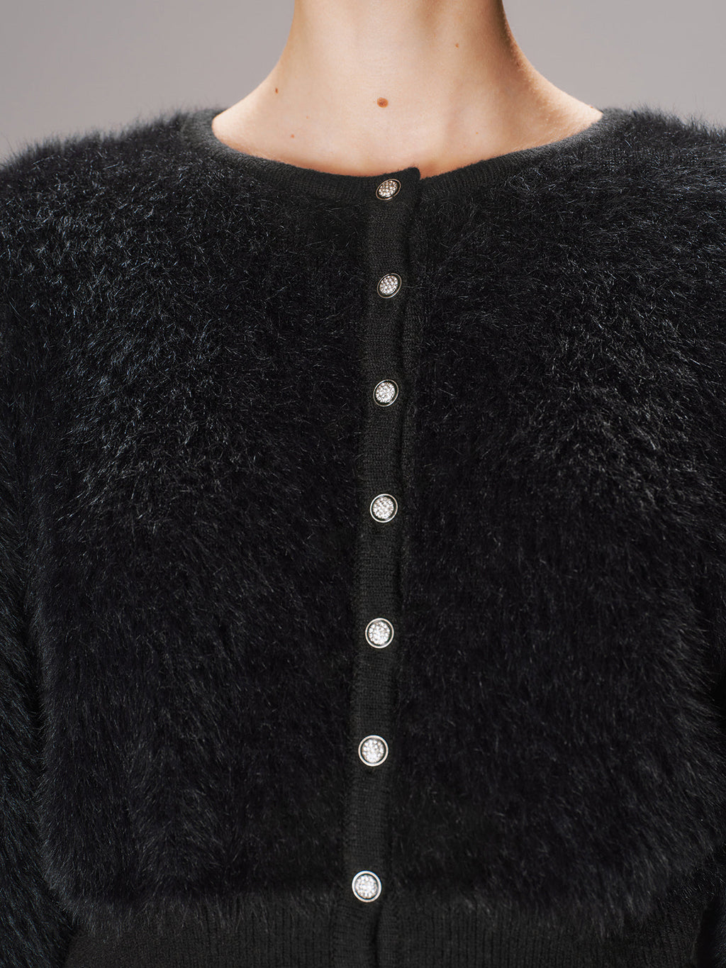 Textured black knit faux mink cardigan with shiny round buttons and cropped silhouette.