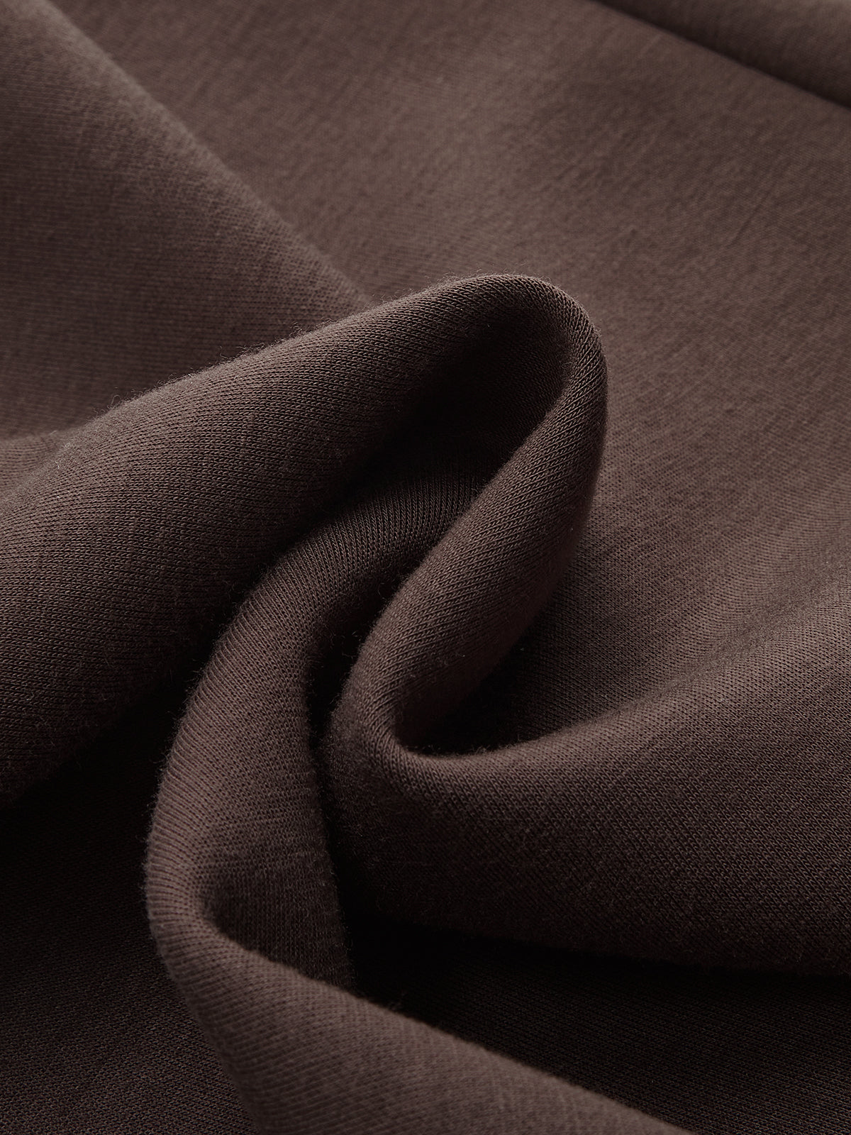 A close-up of the soft, dark brown LA FINE FLEUR pullover sweatshirt fabric and folds.