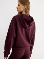 A casual hoodie featuring embroidered LA FINE FLEUR lettering in a relaxed, comfortable design.