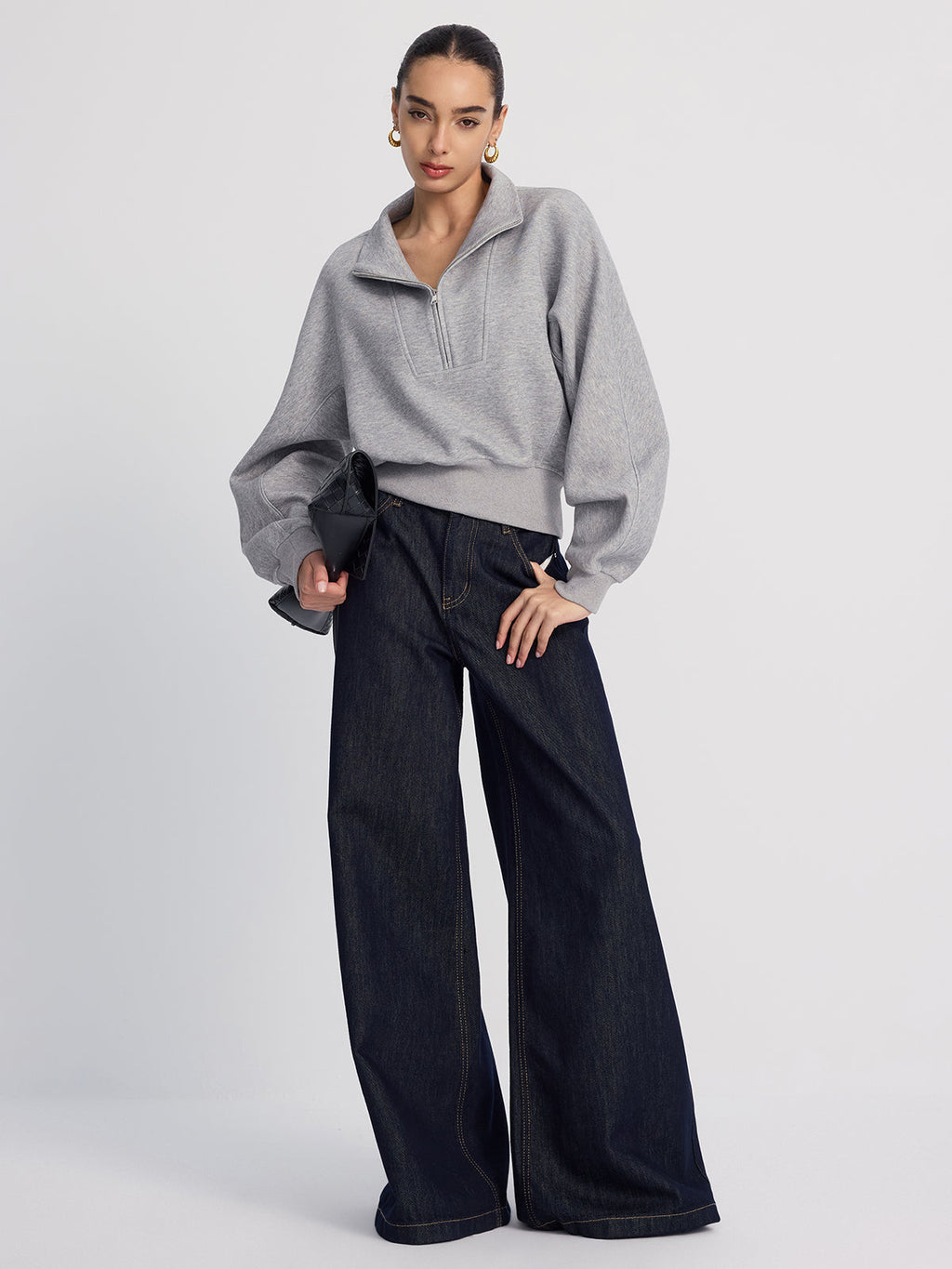 Gray LA FINE FLEUR half-zip cropped sweatshirt with oversized fit and dark wide-leg jeans.