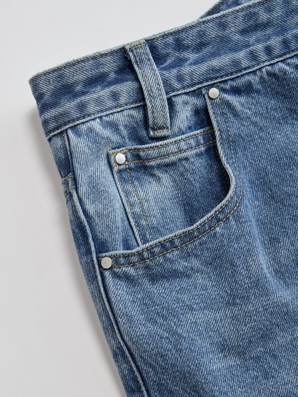 Mid-waist wide-leg jeans with asymmetric cut, blue waistband, belt loop, pocket, stitching.