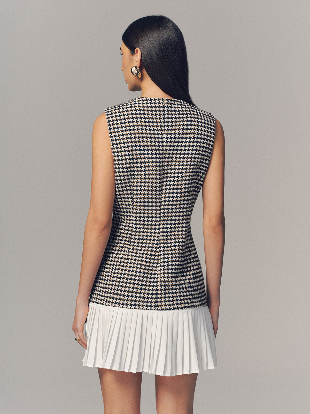 A houndstooth sleeveless mini dress with a pleated hem by LA FINE FLEUR.